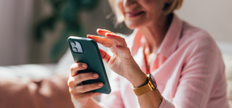 Senior uses phone to research a Digital Decluttering Guide