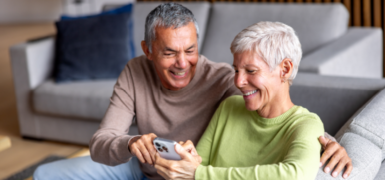 Consumer Cellular logo alongside lifestyle image of people holding a phone.