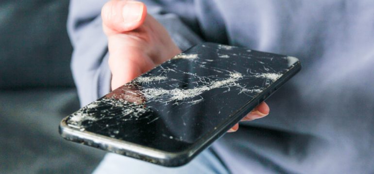 Person holding a smartphone, considering whether to add a device protect